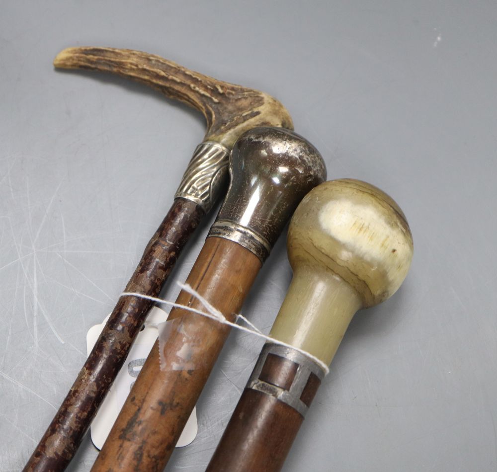 Two walking canes, one with horn handle, the other silver mounted handle, together with a riding crop
